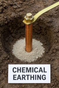 Close-up of a copper earthing rod embedded in soil with surrounding white chemical compound. A label reads "CHEMICAL EARTHING." Solid and grounded tone.