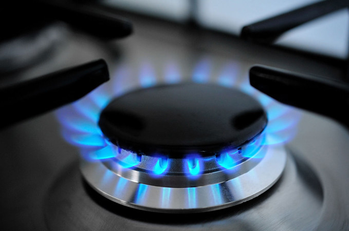 Blue flame on modern kitchen stove burner close-up view